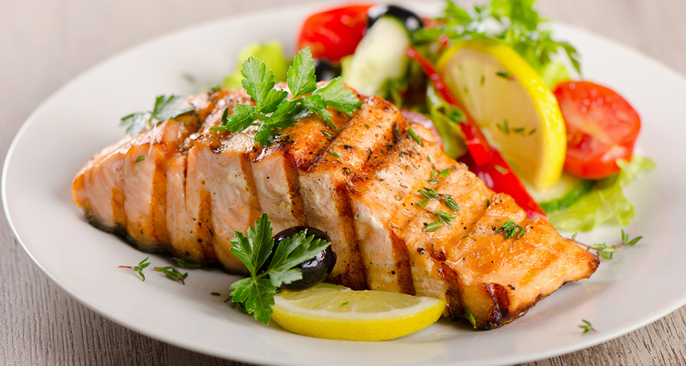 A plate of grilled salmon with a side salad.